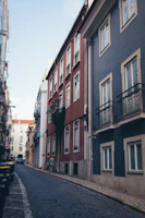 Traveler exploring narrow cobblestone street lined with colorful houses.