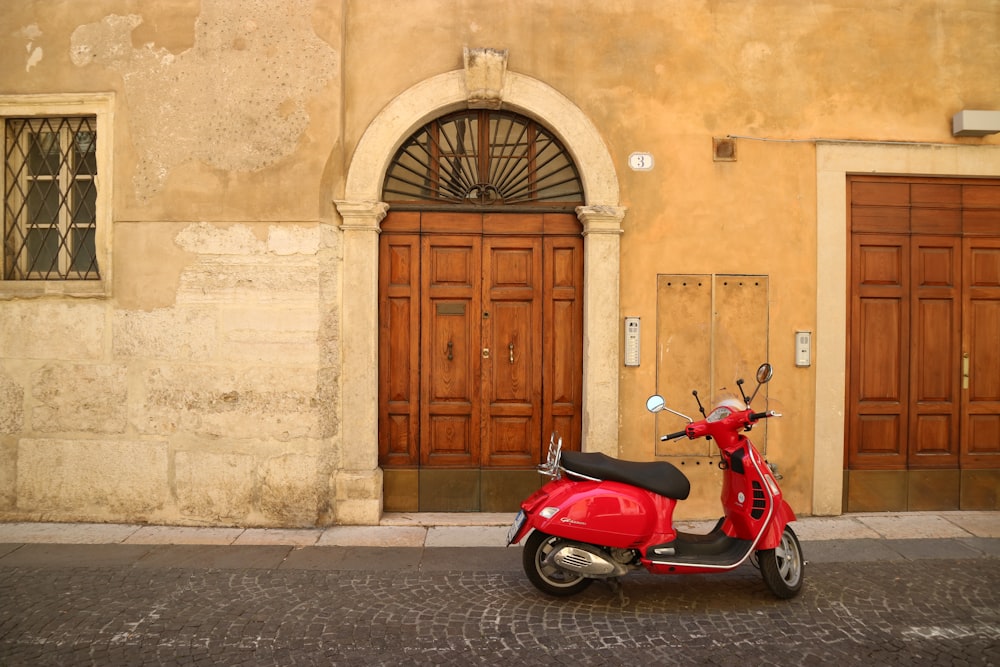 a red scooter parked in front of a building