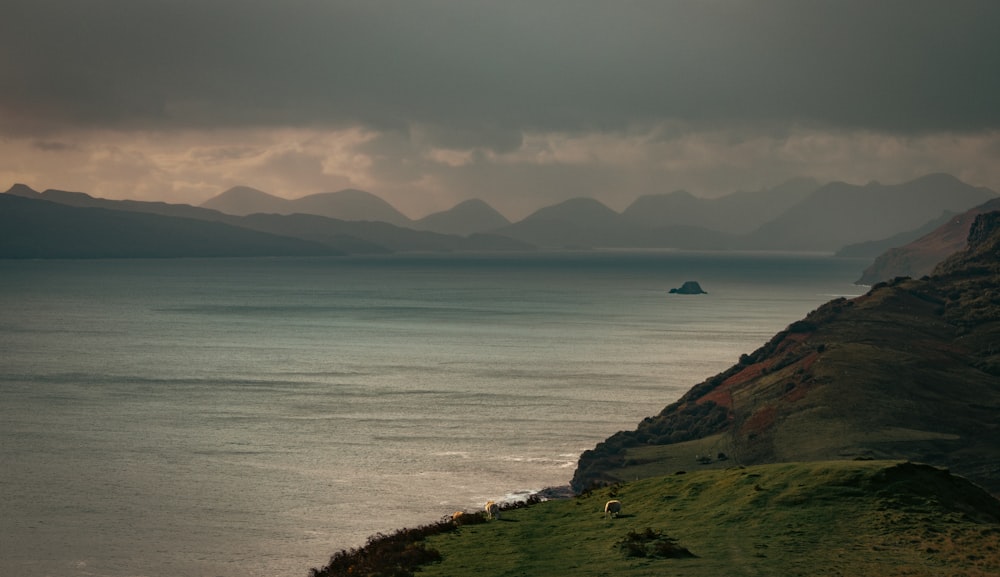 a large body of water with mountains in the background