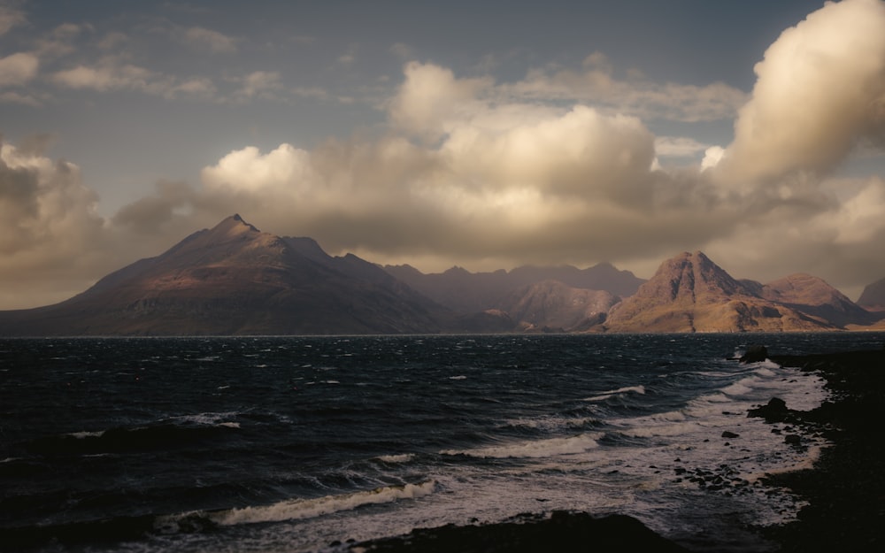 a large body of water with mountains in the background