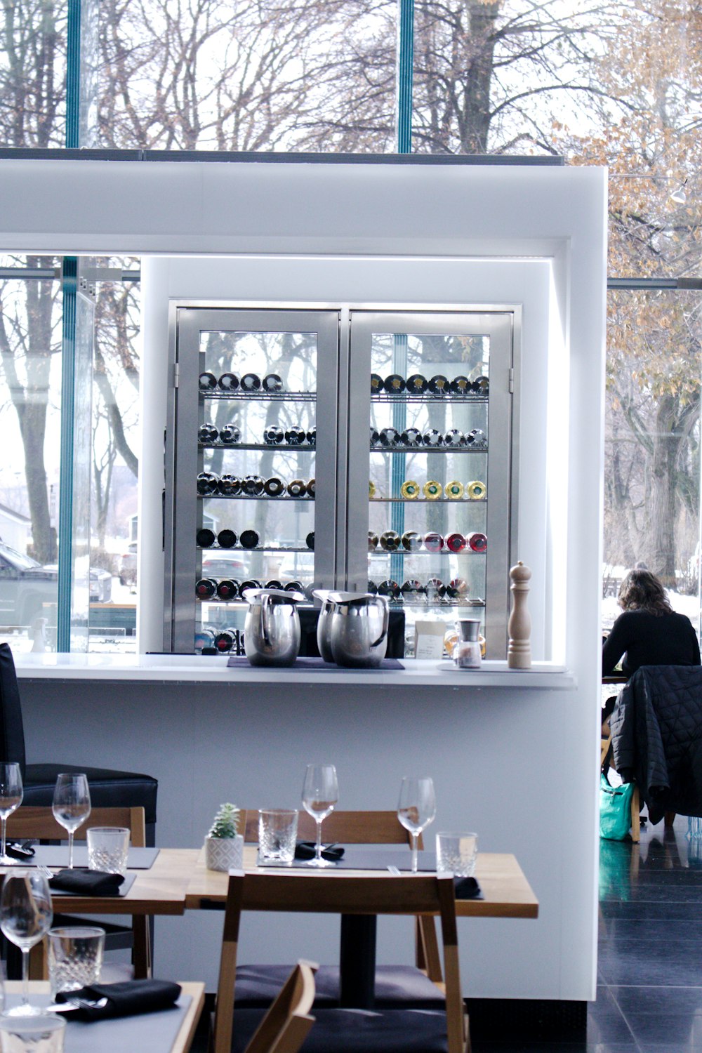 a restaurant with tables and chairs and a wine cooler