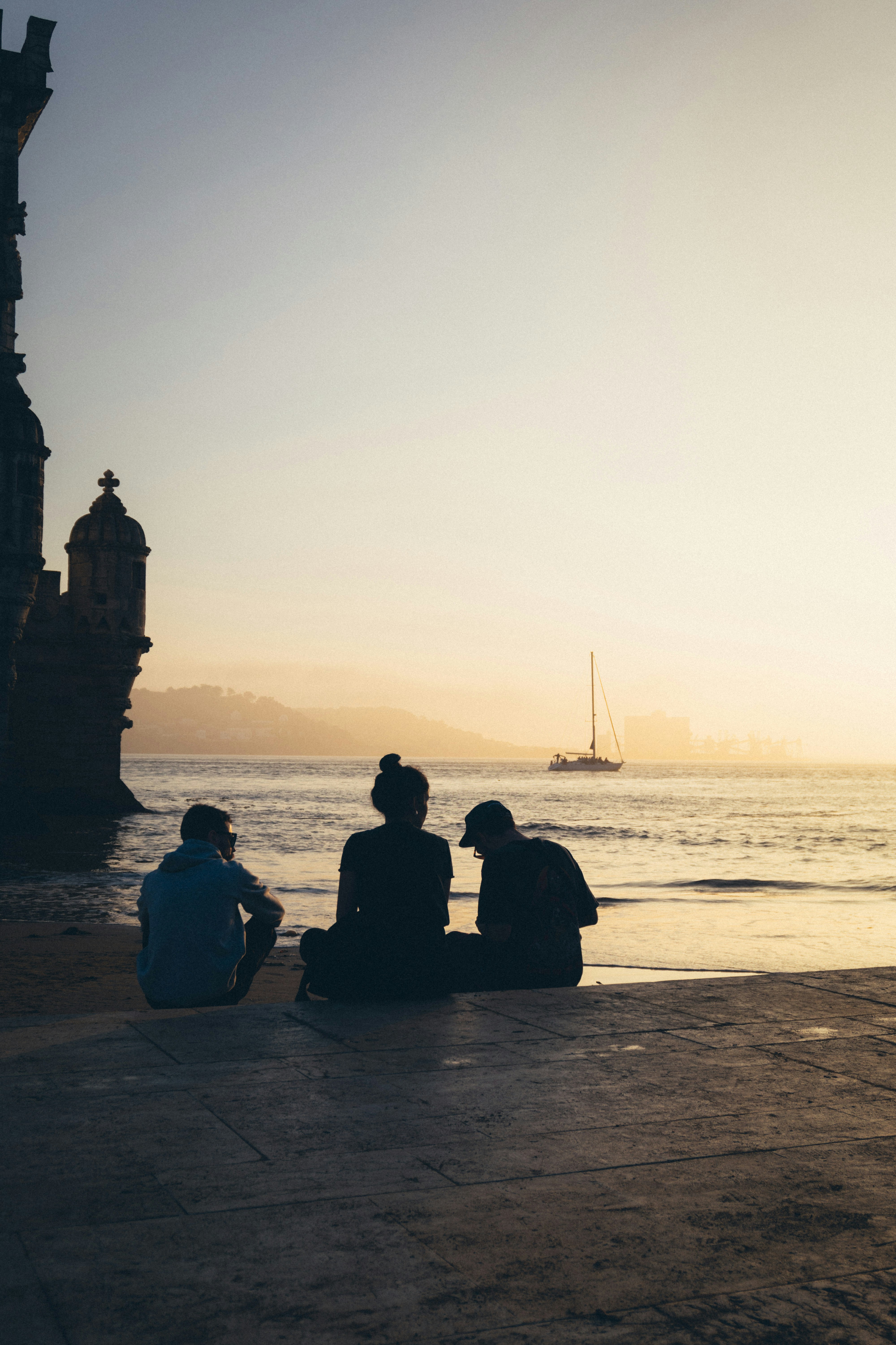 a group of people sitting on top of a beach next to the ocean