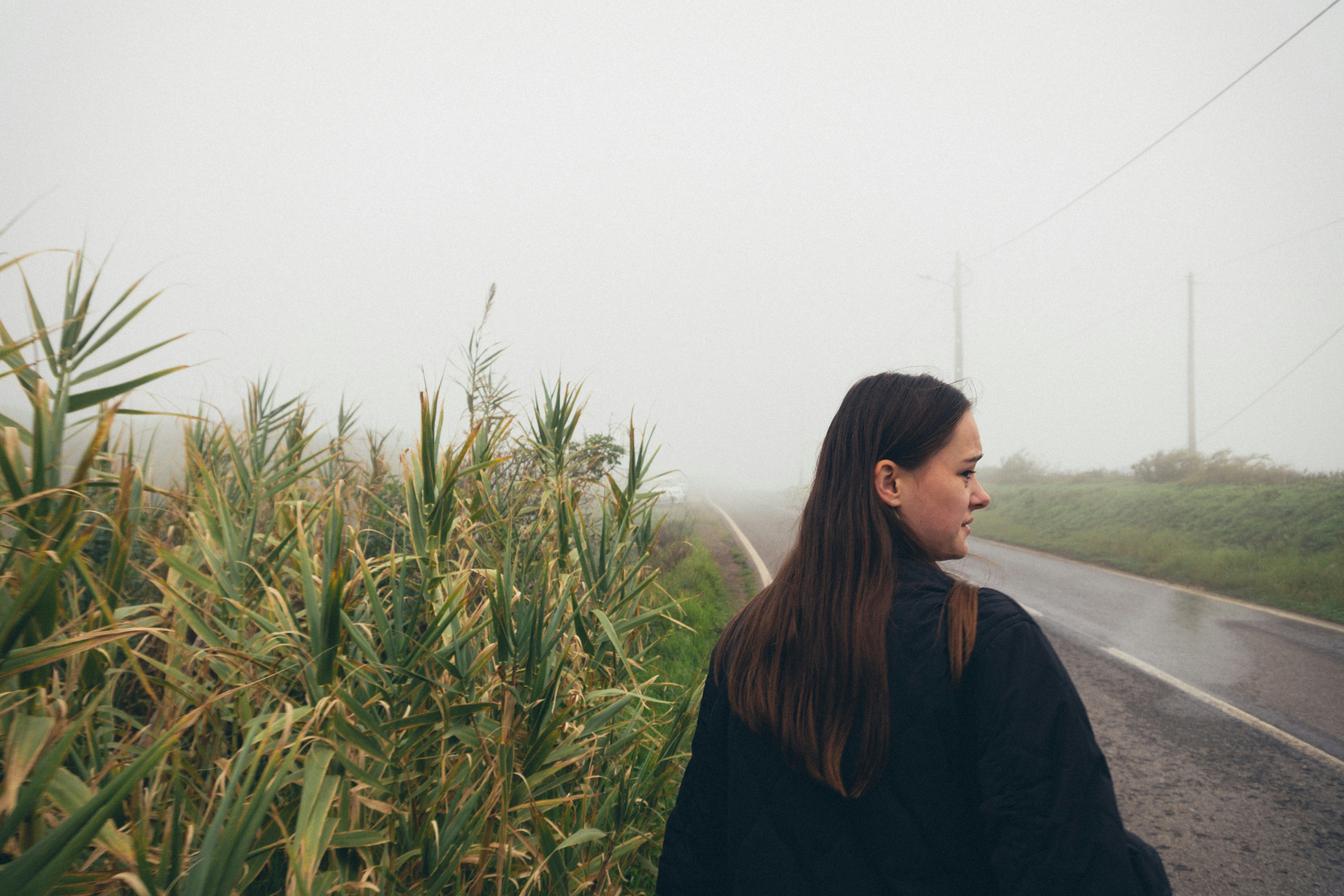 a woman standing on the side of a road