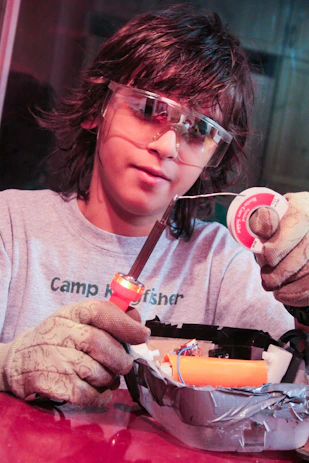 a person wearing goggles and holding a cigarette