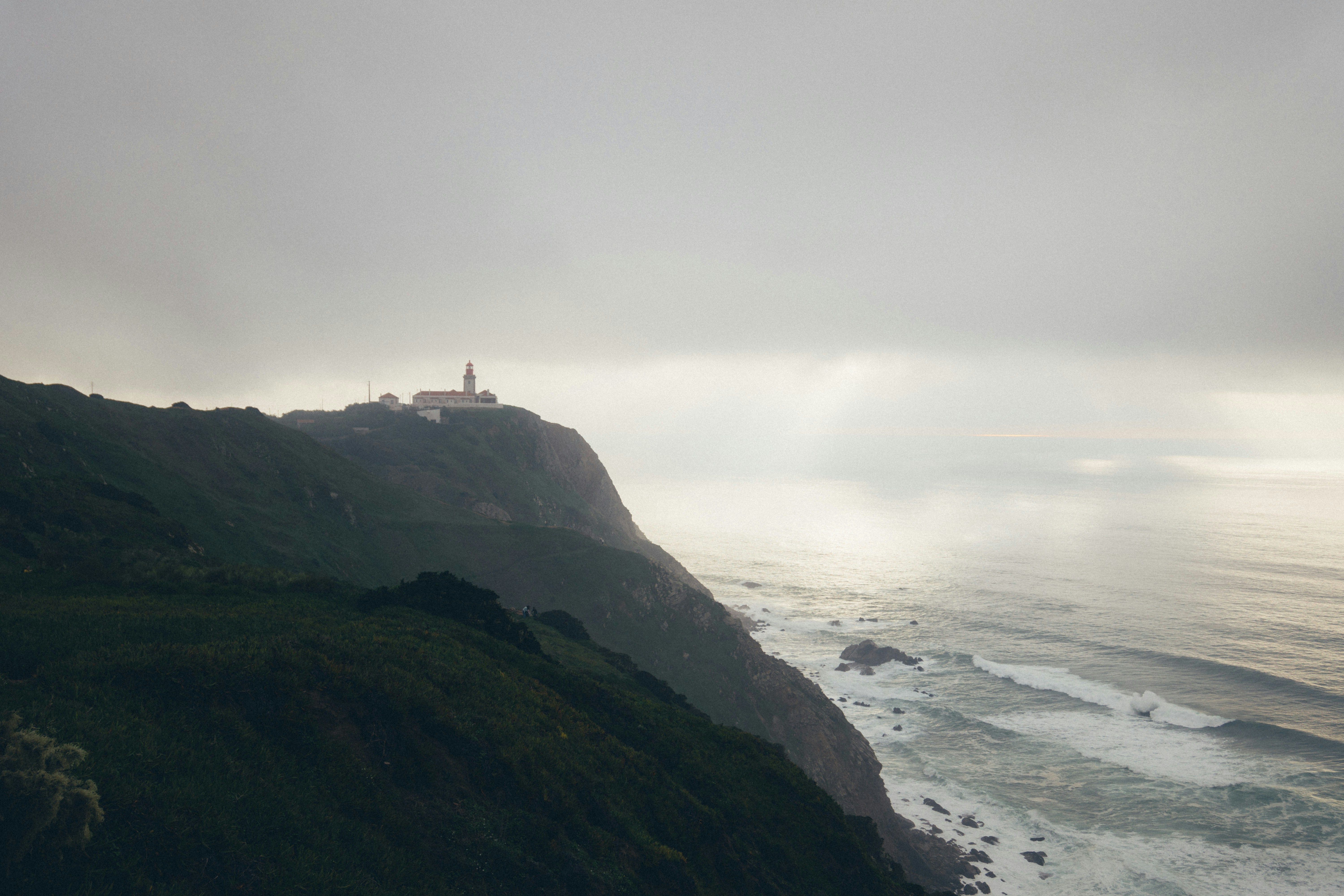a lighthouse on a cliff overlooking the ocean