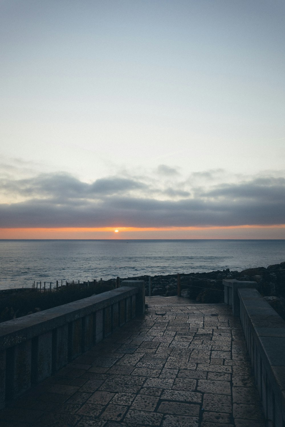 a bench sitting on the side of a road next to the ocean