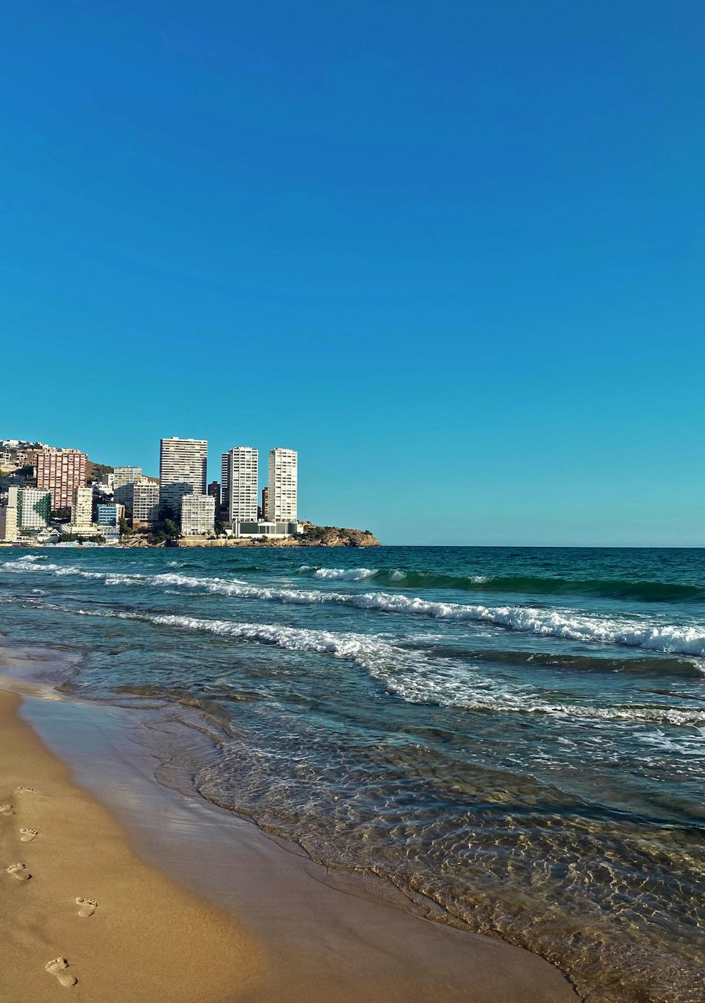 Una playa con una ciudad de fondo