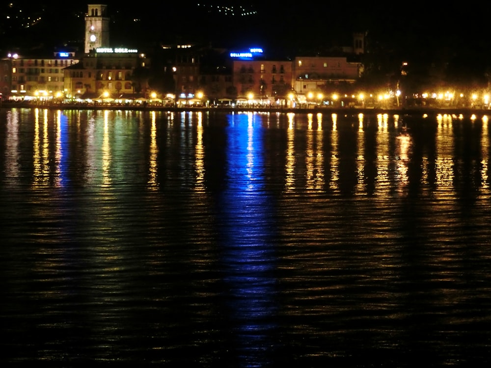 a body of water at night with a city in the background