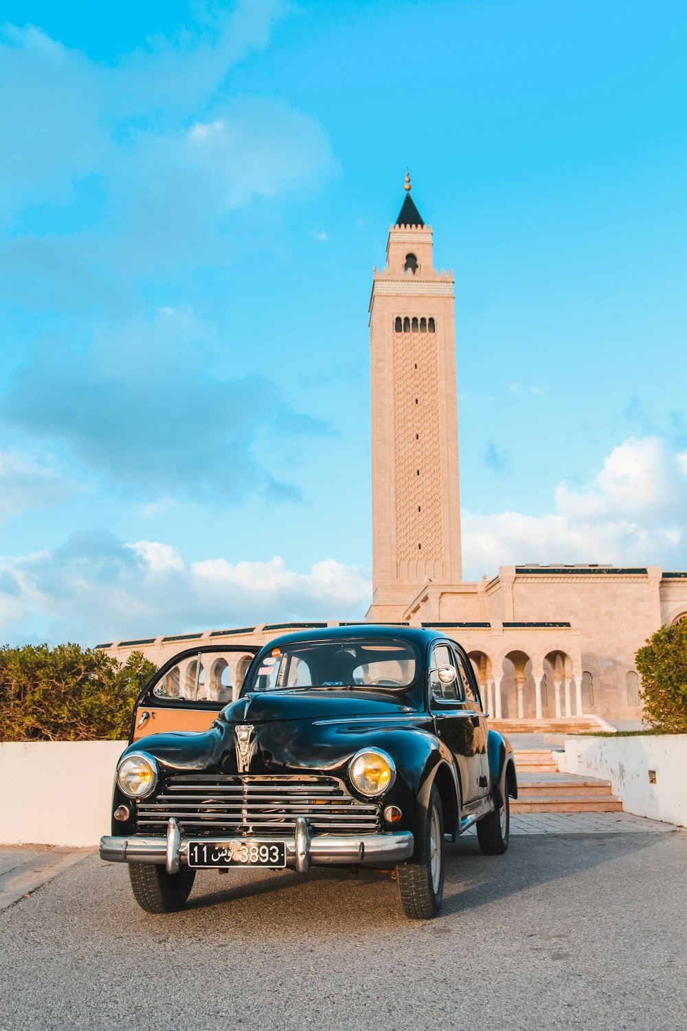 a vintage car parked in front of a tall building