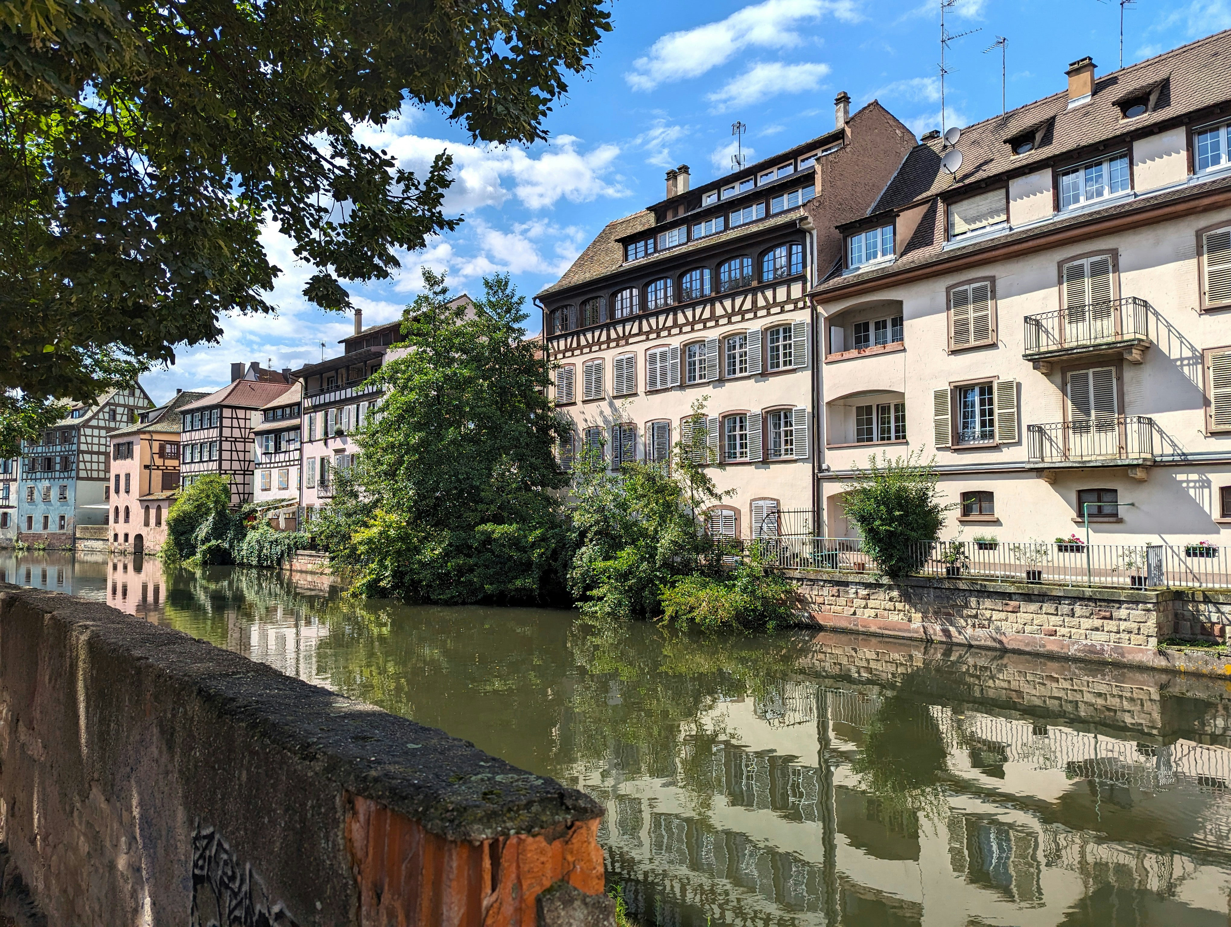 Une rivière qui traverse une ville à côté de grands immeubles photo Photo Strasbourg Gratuite