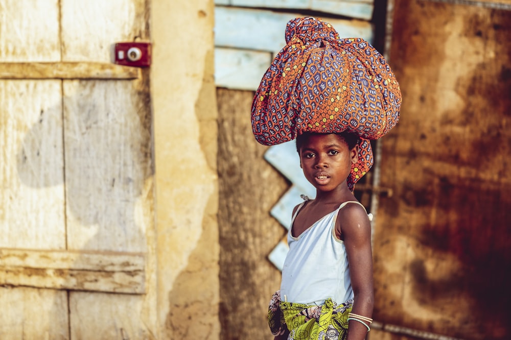 a young girl with a big hat on her head