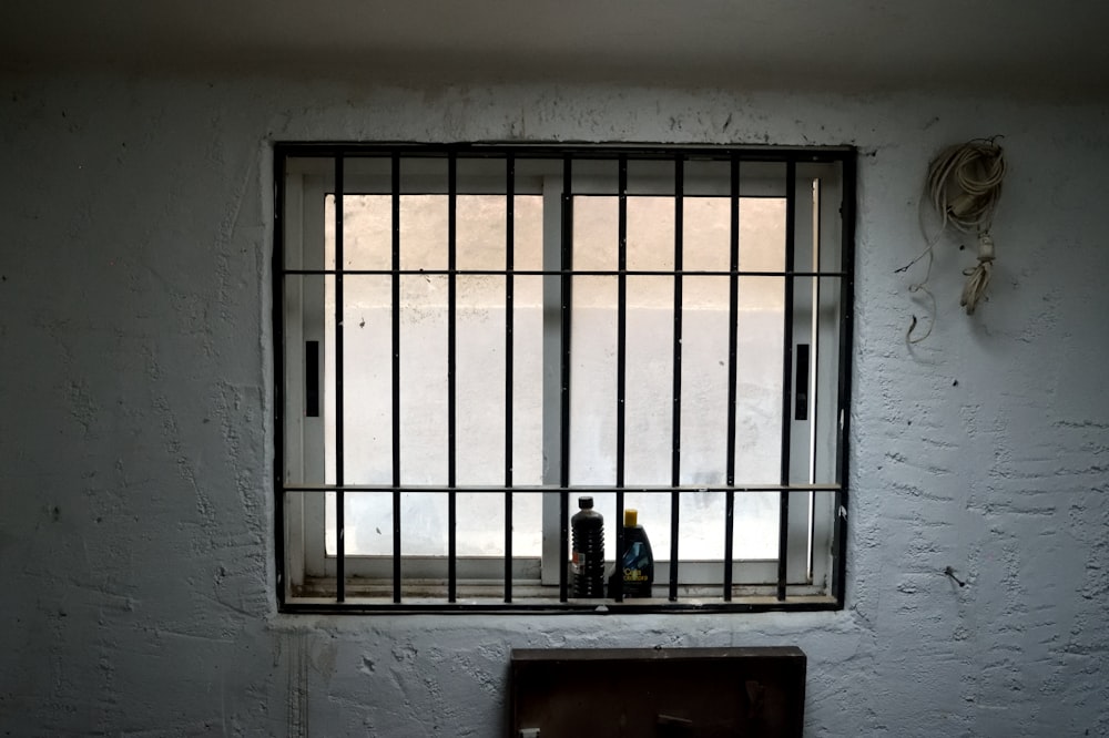 a jail cell with two bottles of alcohol behind bars