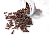 a glass jar filled with cloves on top of a white table
