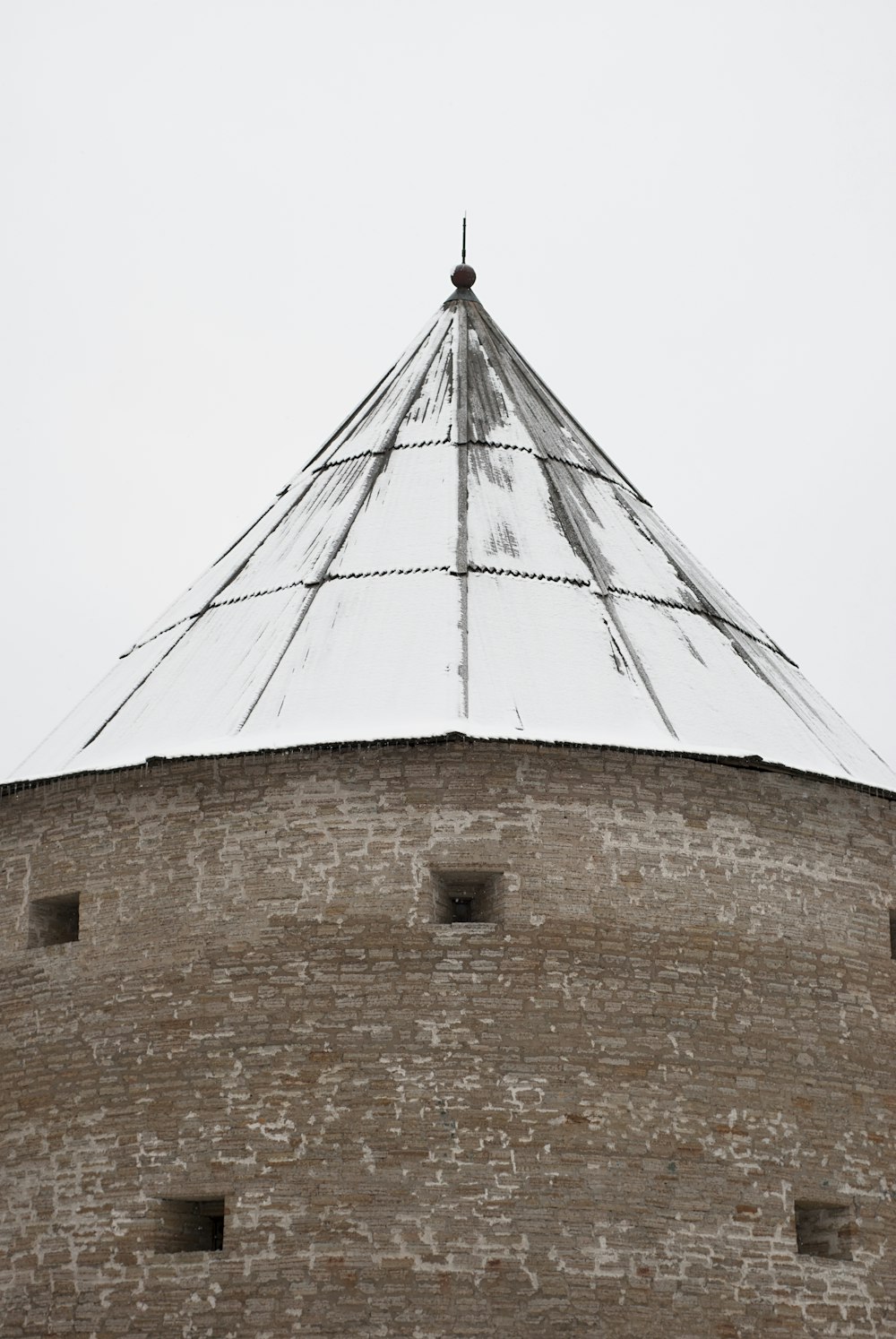 a tall brick tower with a metal roof