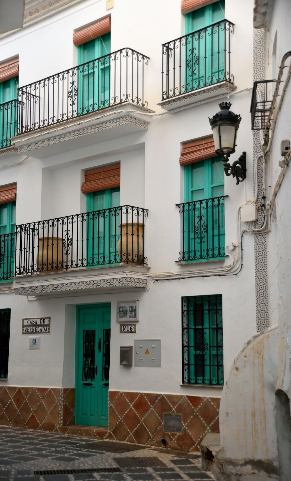 a white building with green doors and balconies