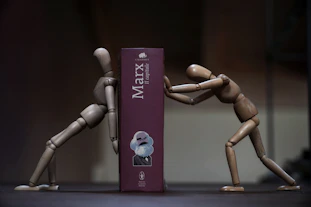 a couple of wooden mannequins standing next to a box