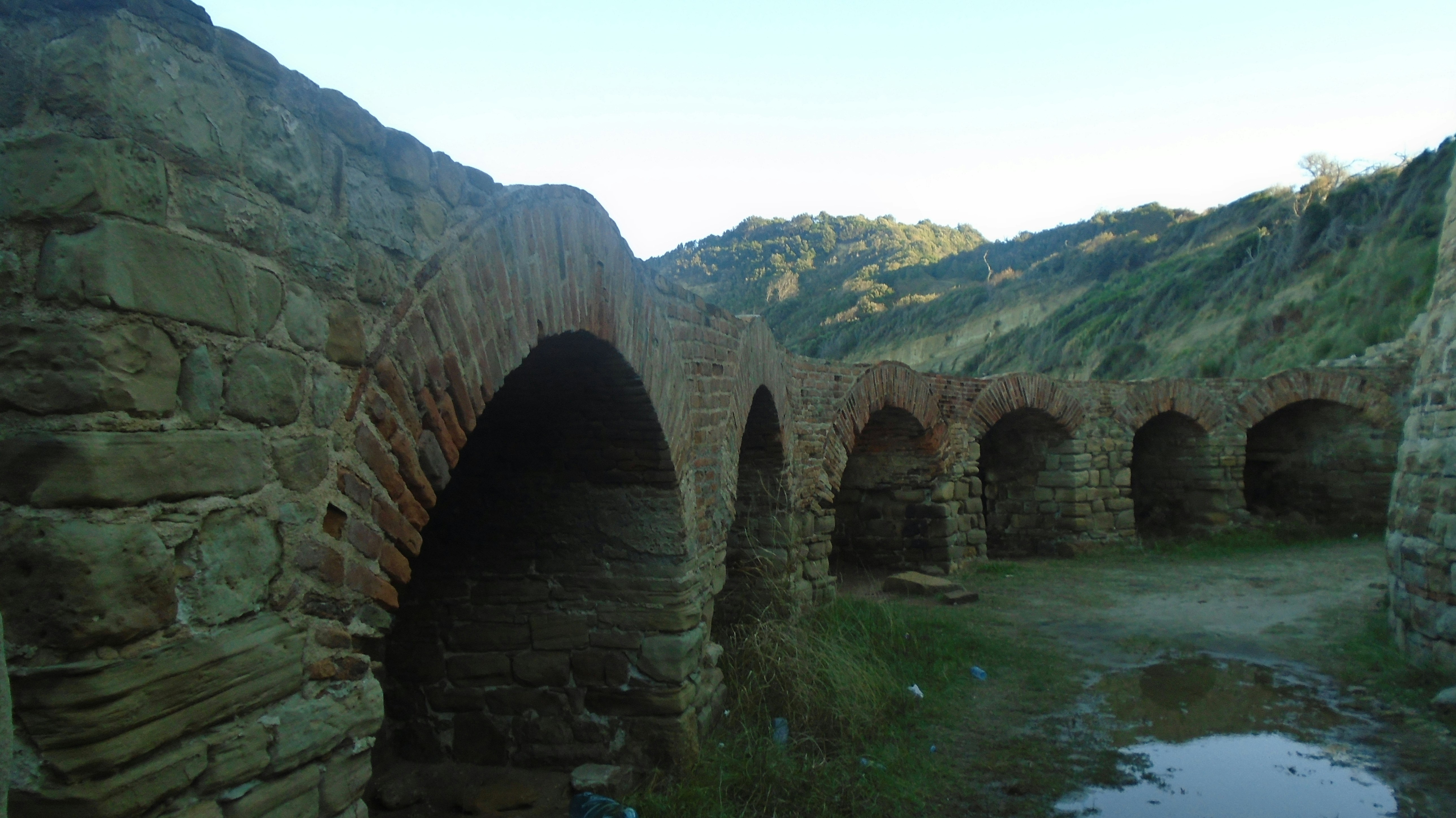 a stone wall with a tunnel in the middle of it