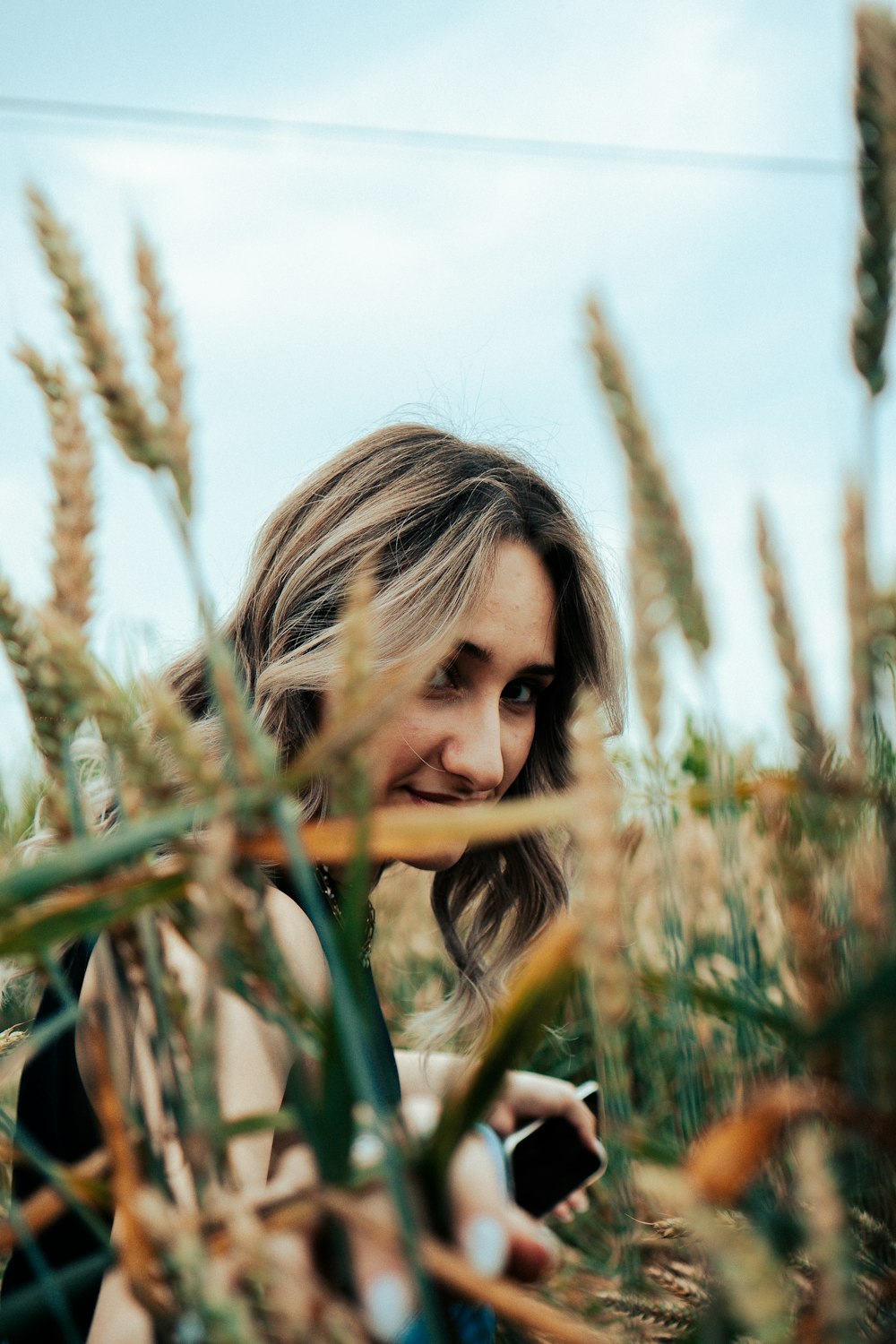 a woman sitting in a field of tall grass