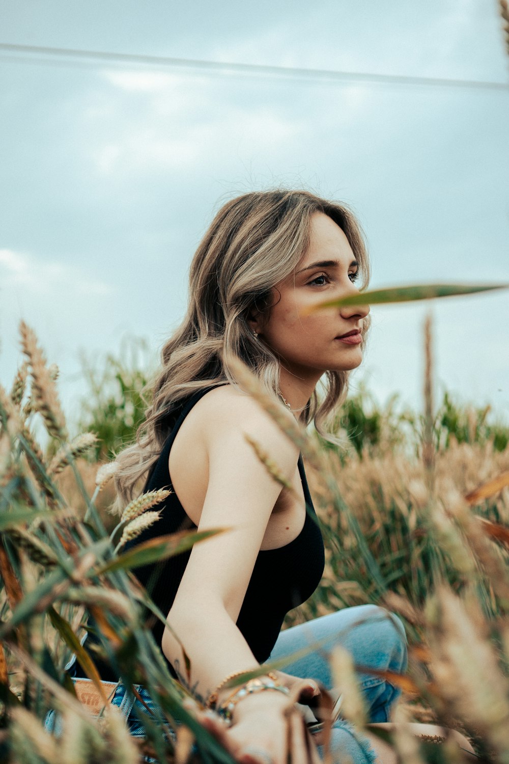 a woman sitting in a field of tall grass