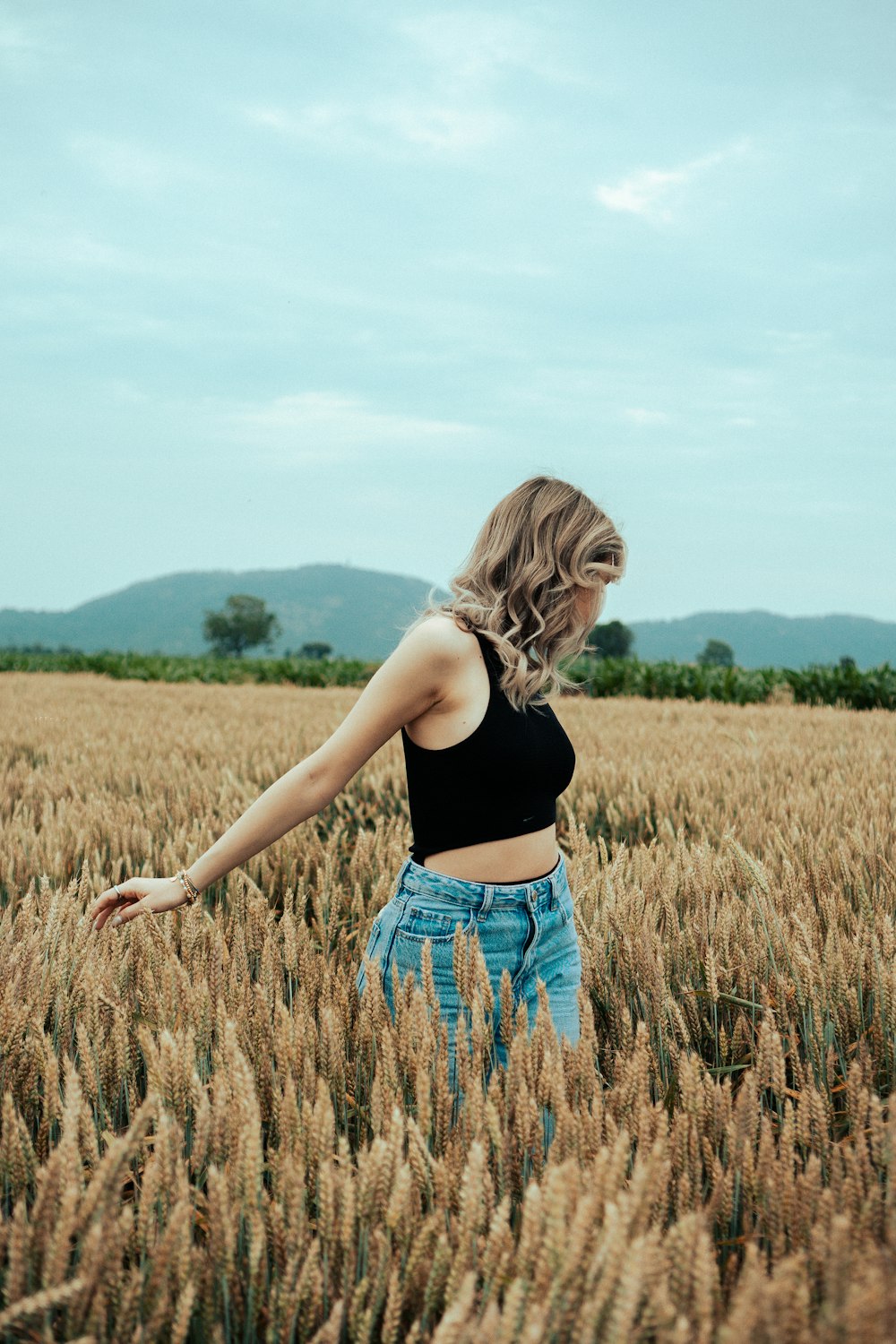 a woman standing in a field of wheat