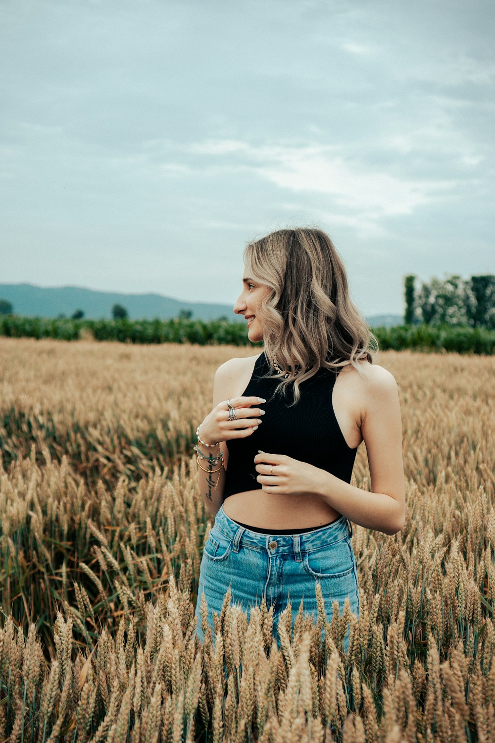 a woman standing in a field of wheat