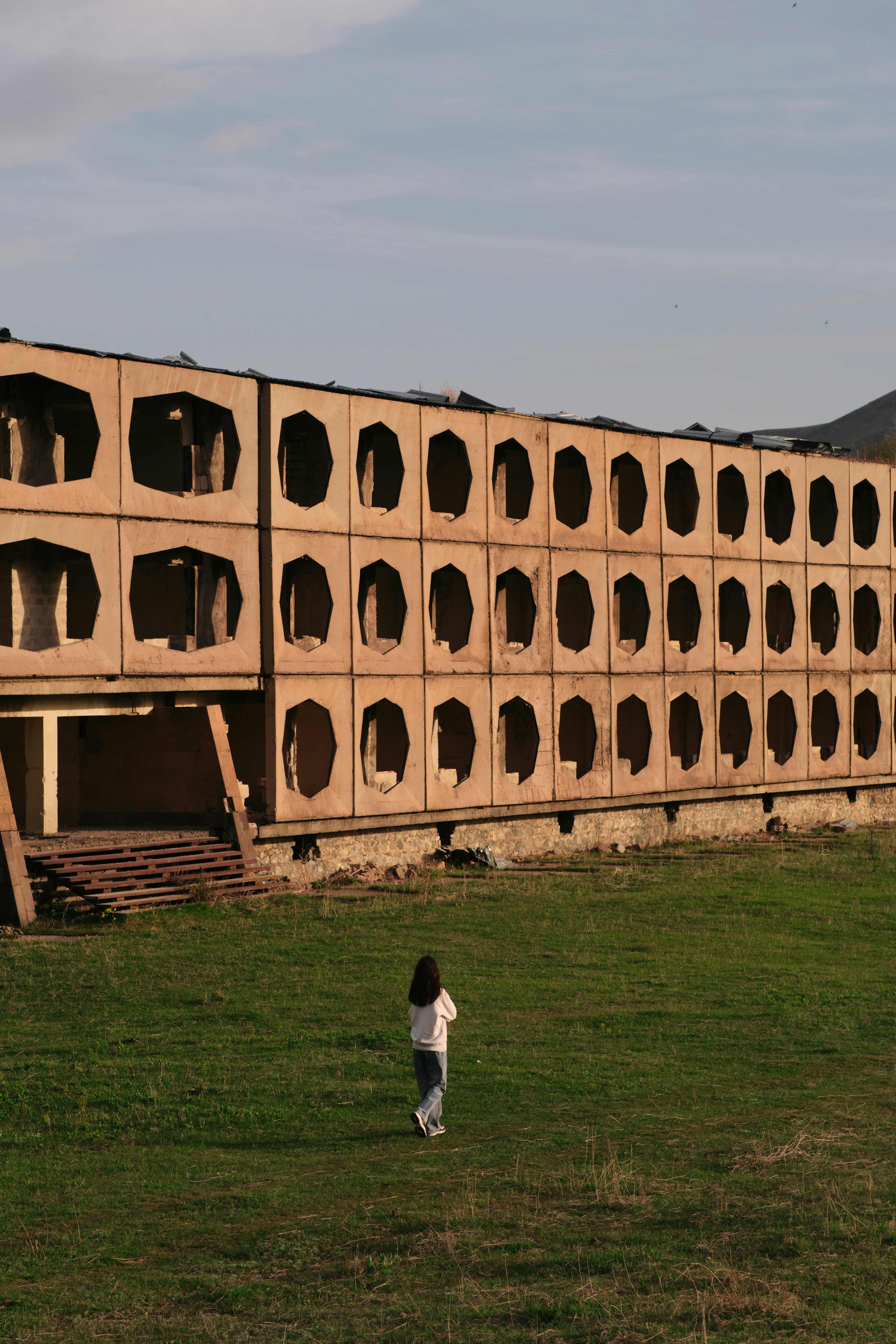 a person walking in a field near a building