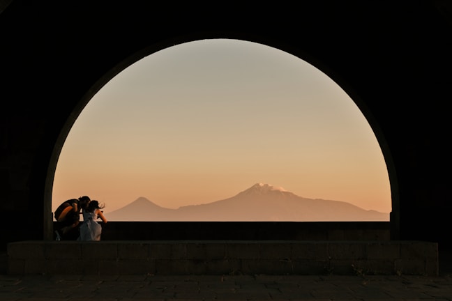 A couple sharing a tender moment beneath the arches of Amer Fort, bathed in warm sunset light.