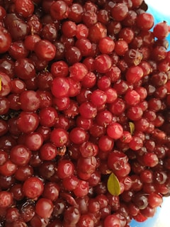 A close-up of colorful berries nestled among green leaves, freshly picked.