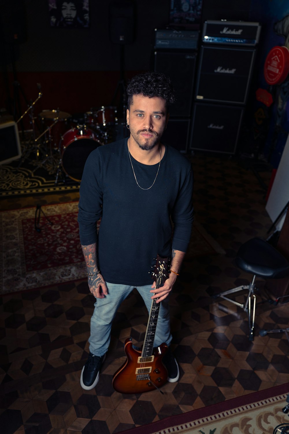 a man standing in a room with a guitar