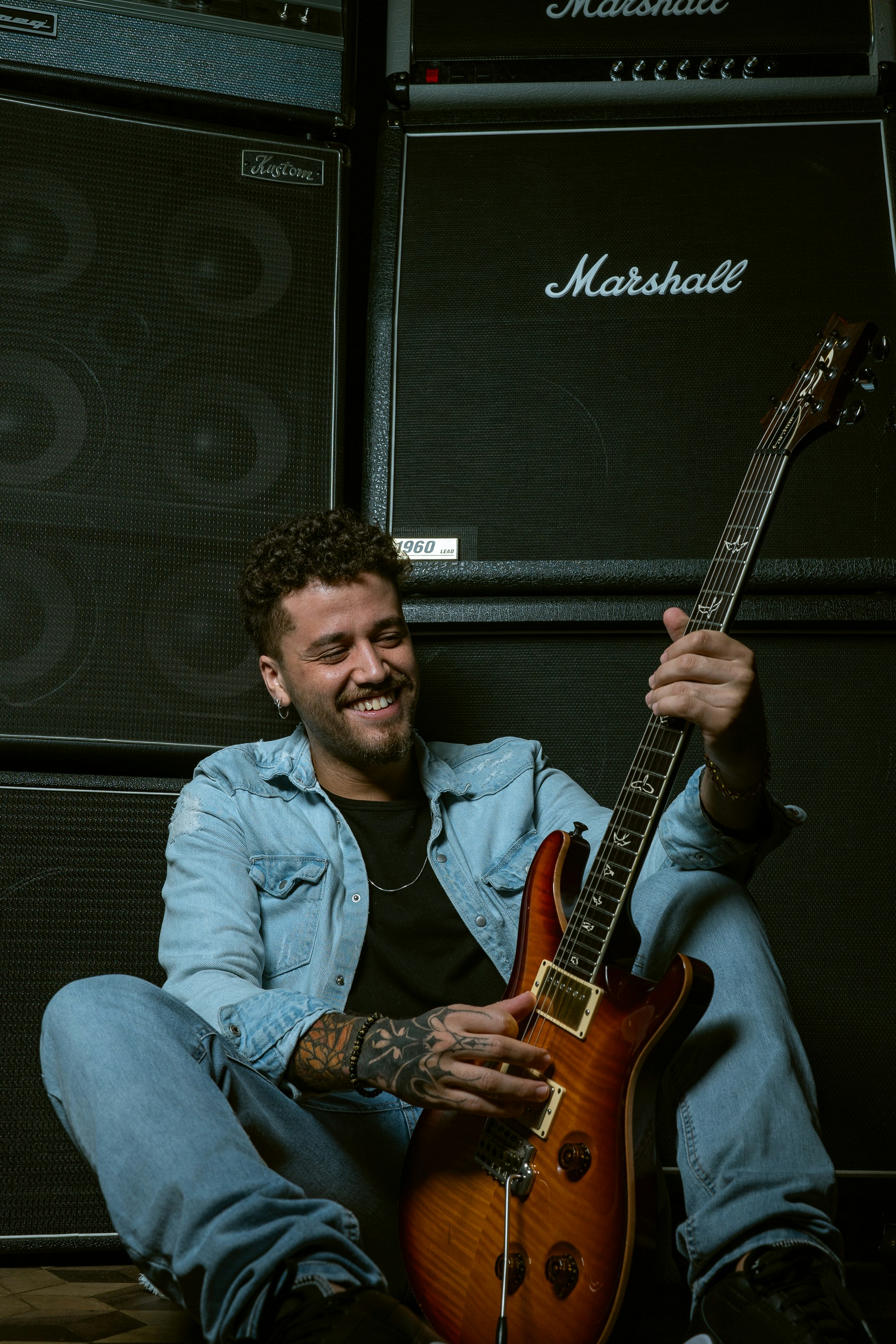 a man sitting on the floor with a guitar