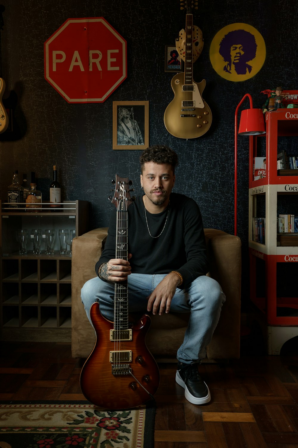 a man sitting on a couch holding a guitar