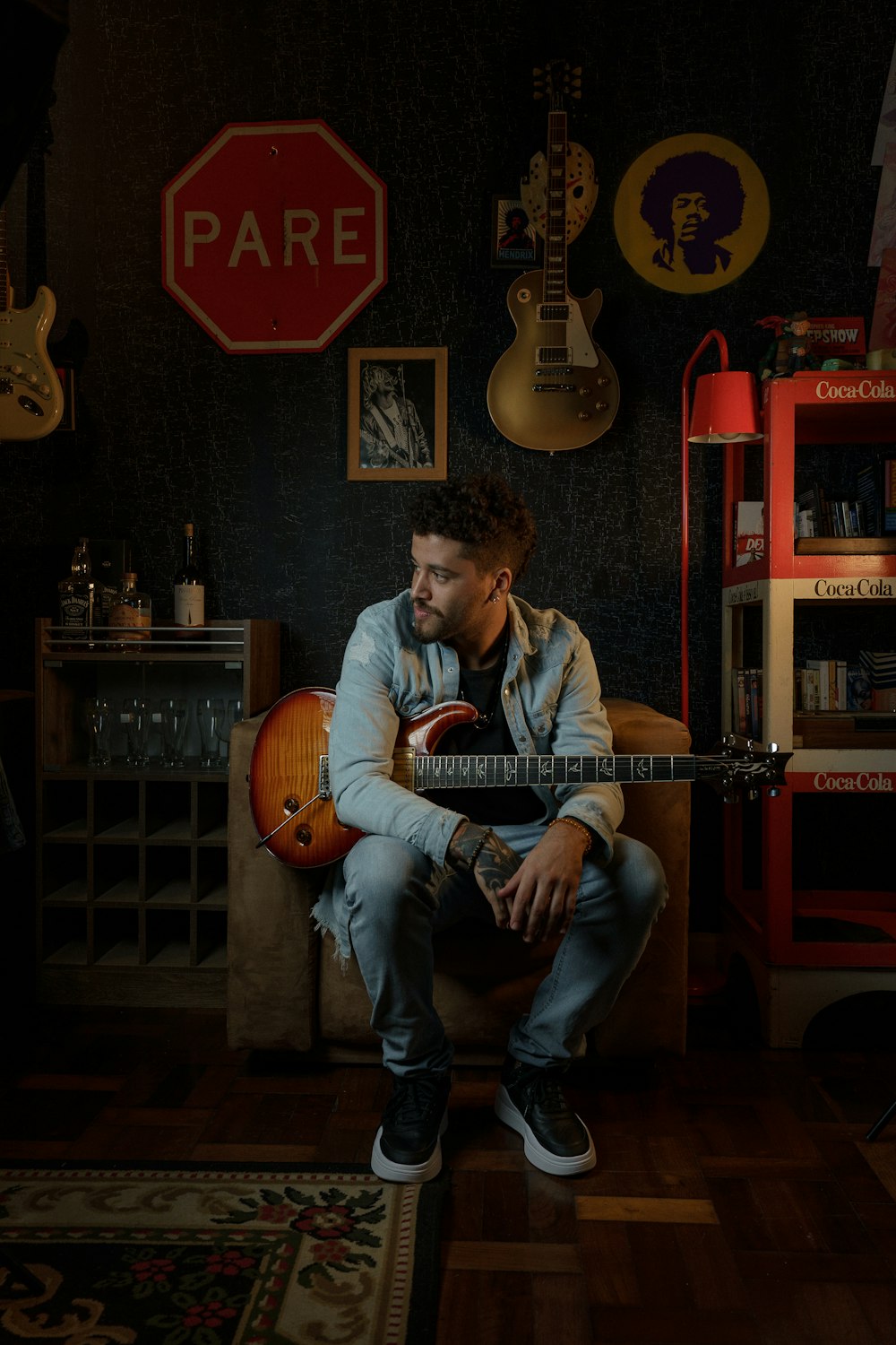 a man sitting in a room with a guitar