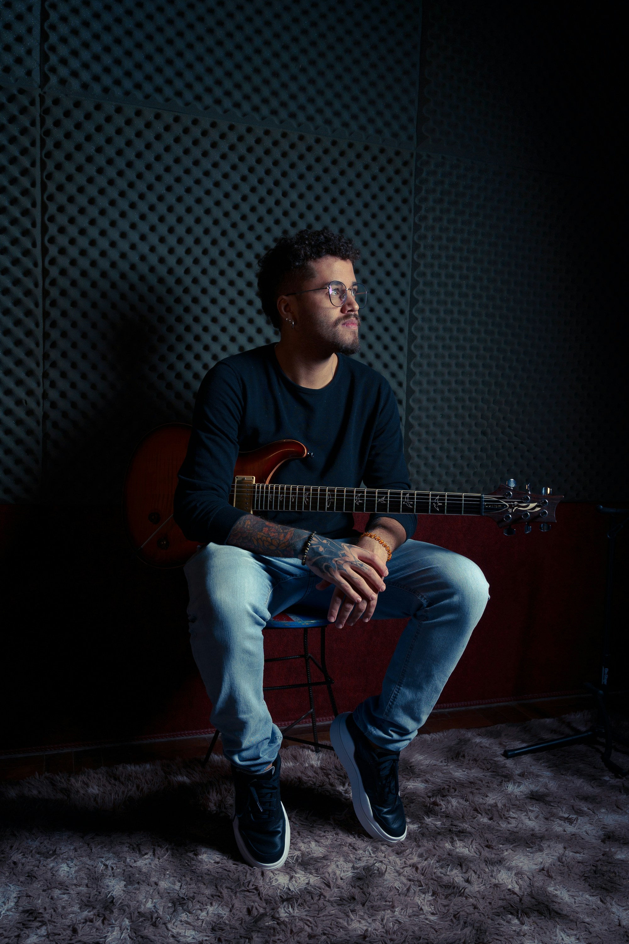 a man sitting on a chair holding a guitar
