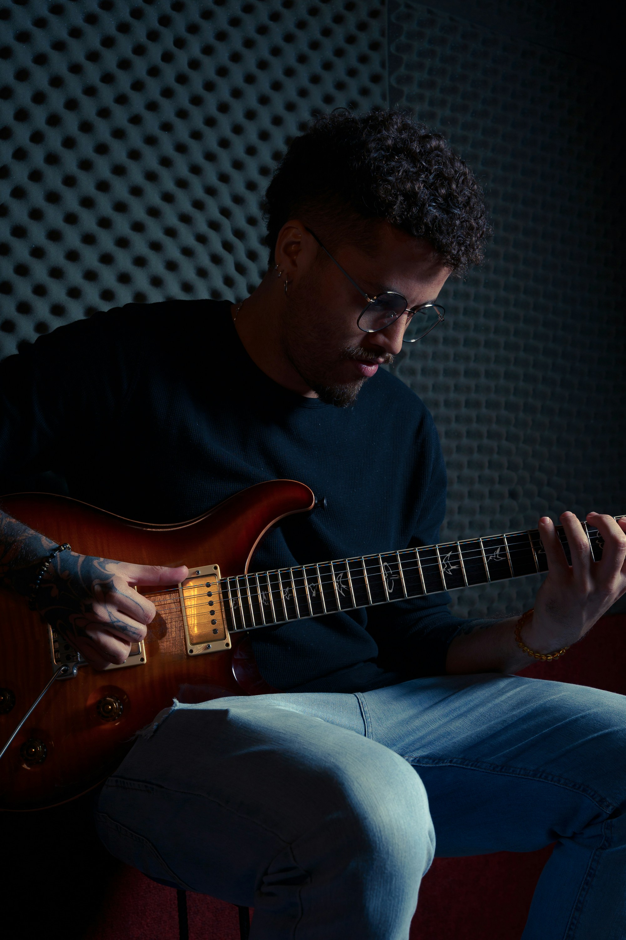 a man sitting in a chair playing a guitar