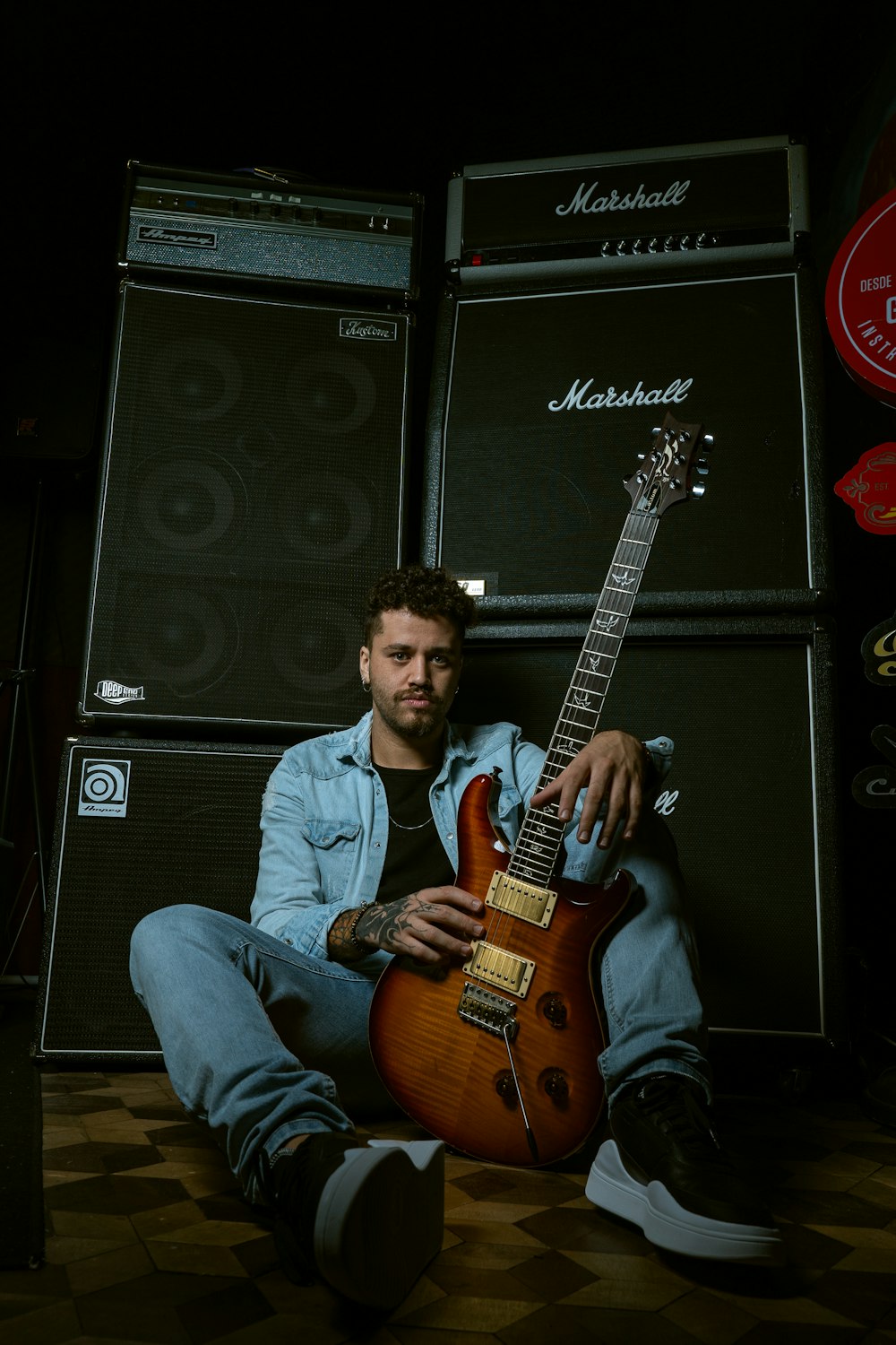 a man sitting on the floor with a guitar