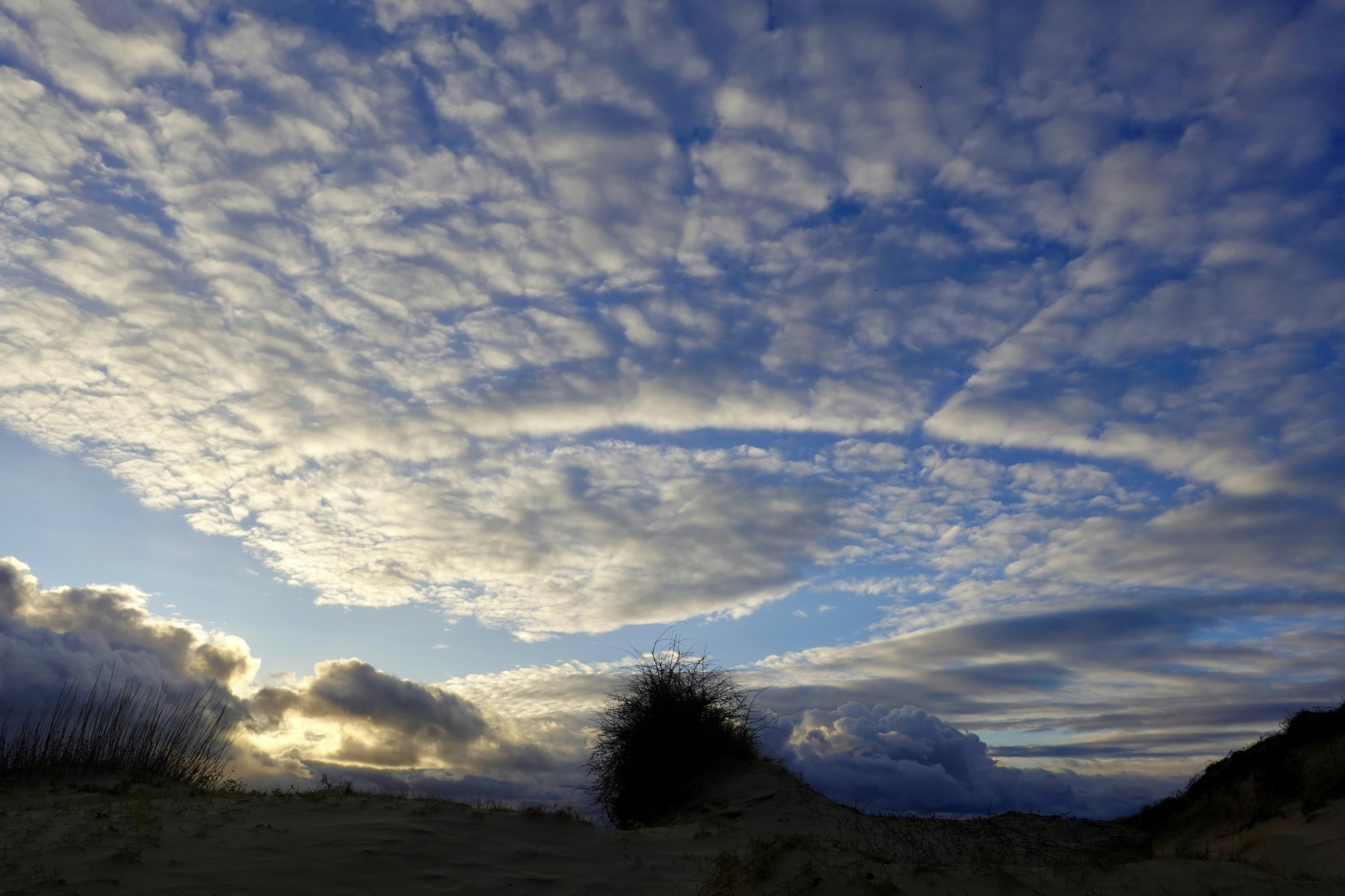 Wolkenlucht boven de Nederlandse duinen met lage regenwolken