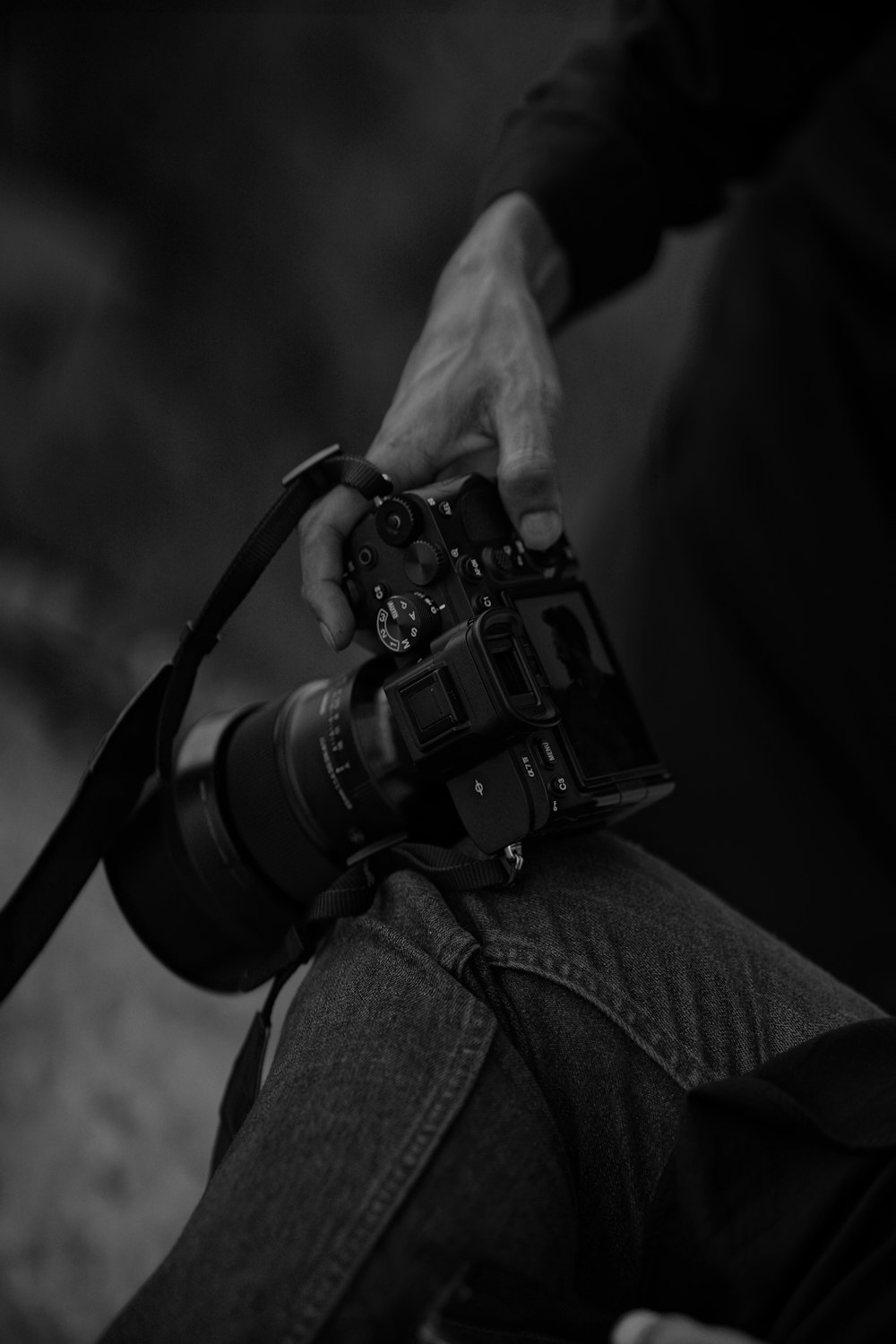 a black and white photo of a person holding a camera