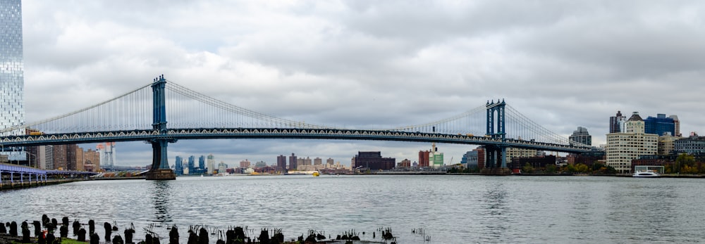 a bridge over a body of water with a city in the background