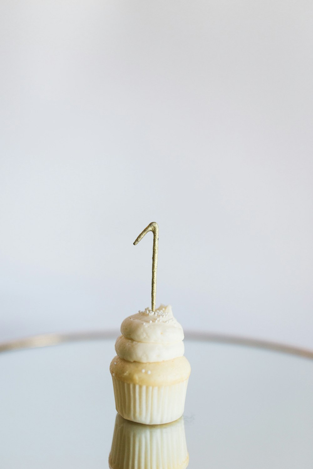 a cupcake with a single candle sticking out of it