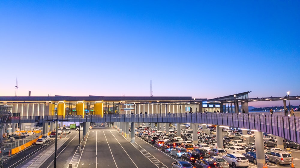 a parking lot filled with lots of cars under a blue sky