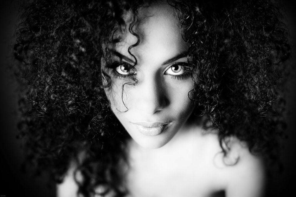 a black and white photo of a woman with curly hair