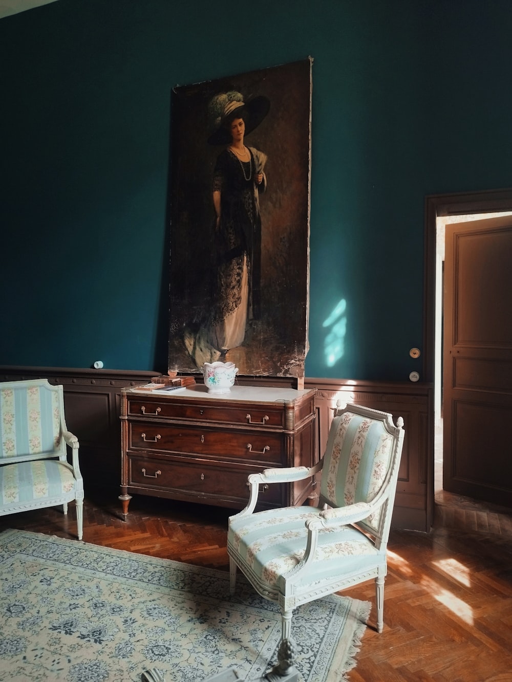 una stanza con una sedia e un quadro sul muro