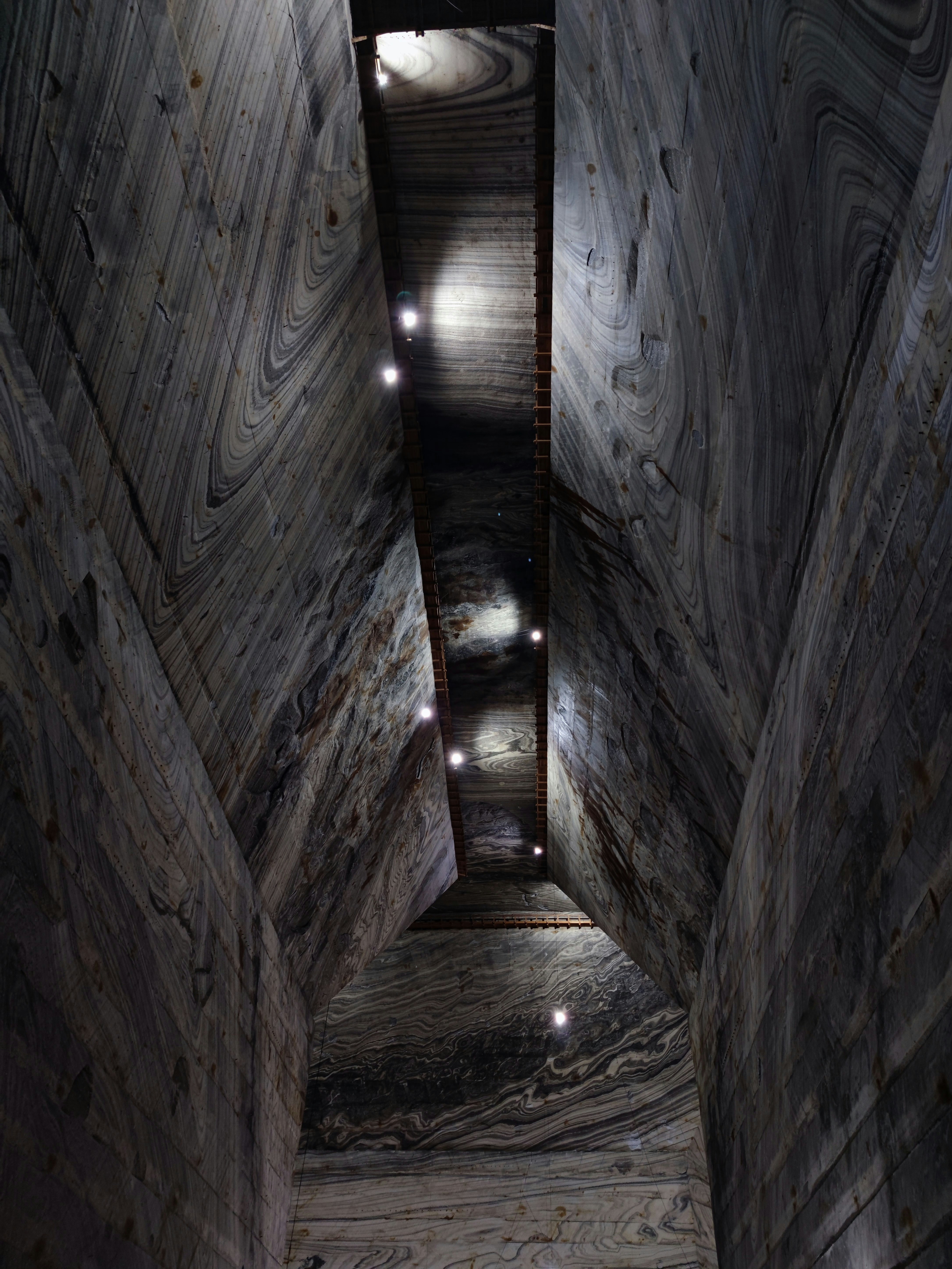 a very long narrow room with some lights on the ceiling