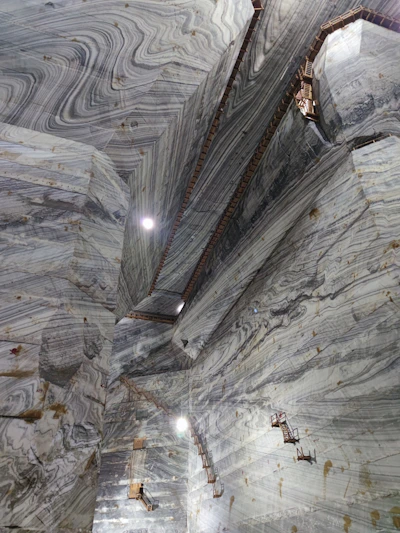 A panoramic view of a bustling Indian marble quarry with workers inspecting large stone blocks.