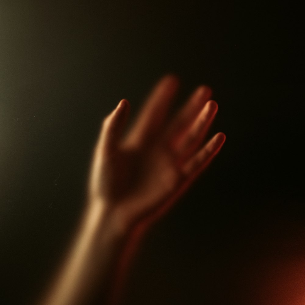 a person's hand reaching up into the air