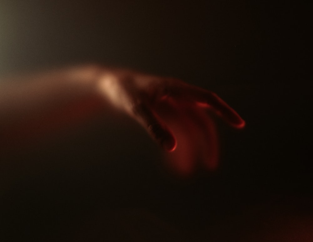 a blurry image of a hand reaching for something