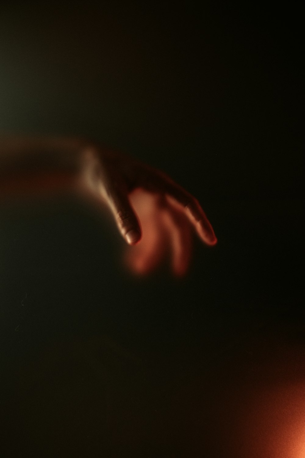 a blurry image of a person's hand reaching for something