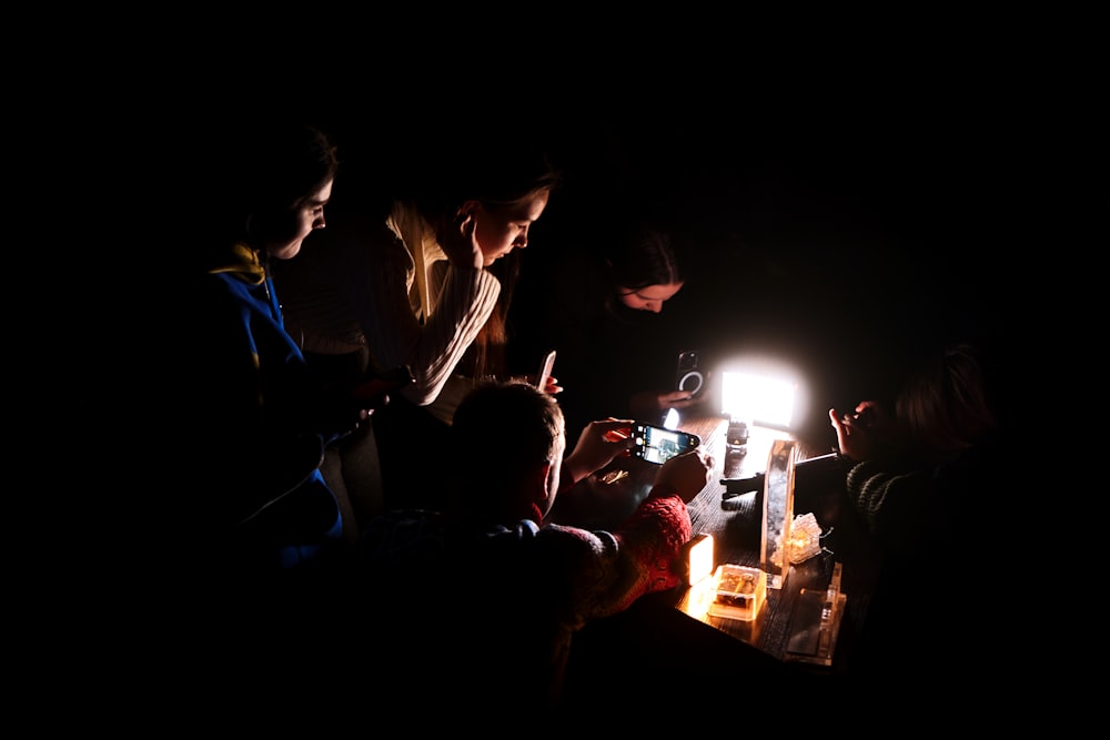 a group of people sitting around a table in the dark