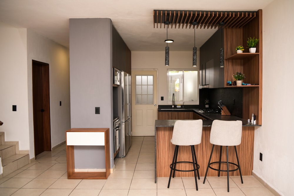 a kitchen with two stools next to a counter