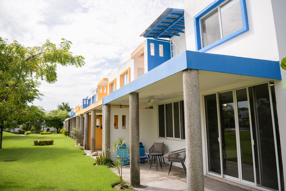 a blue and white building with a lawn in front of it